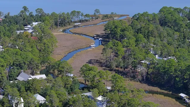 an aerial view of a house with a yard and lake view