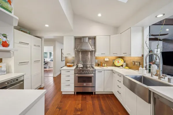 a kitchen with a refrigerator and a stove top oven
