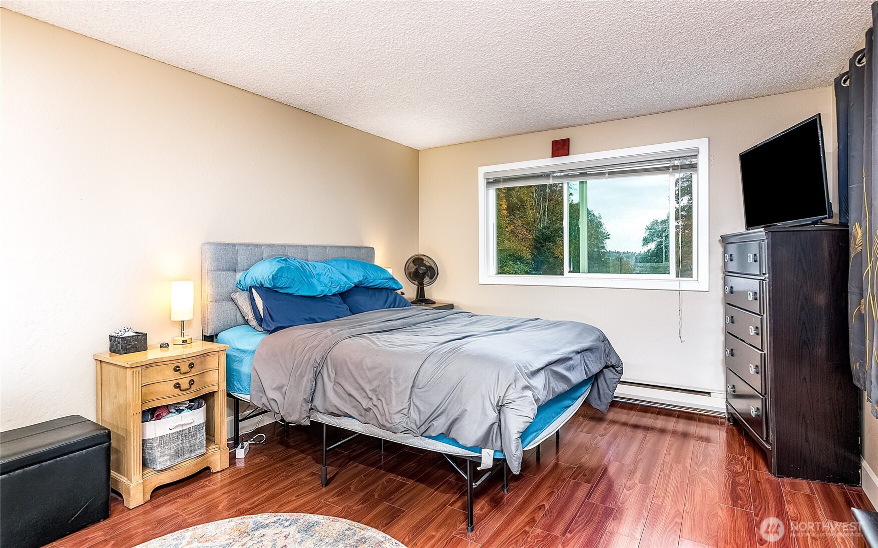 3722 27th Place West, Unit 101 Seattle, WA 98199 - Photo 11 of 17 a bedroom with a bed a flat screen tv and a window