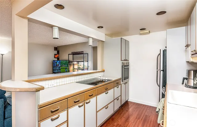 a kitchen that has a sink a stove and a refrigerator