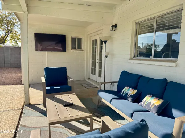 a living room with furniture a flat screen tv and a large window