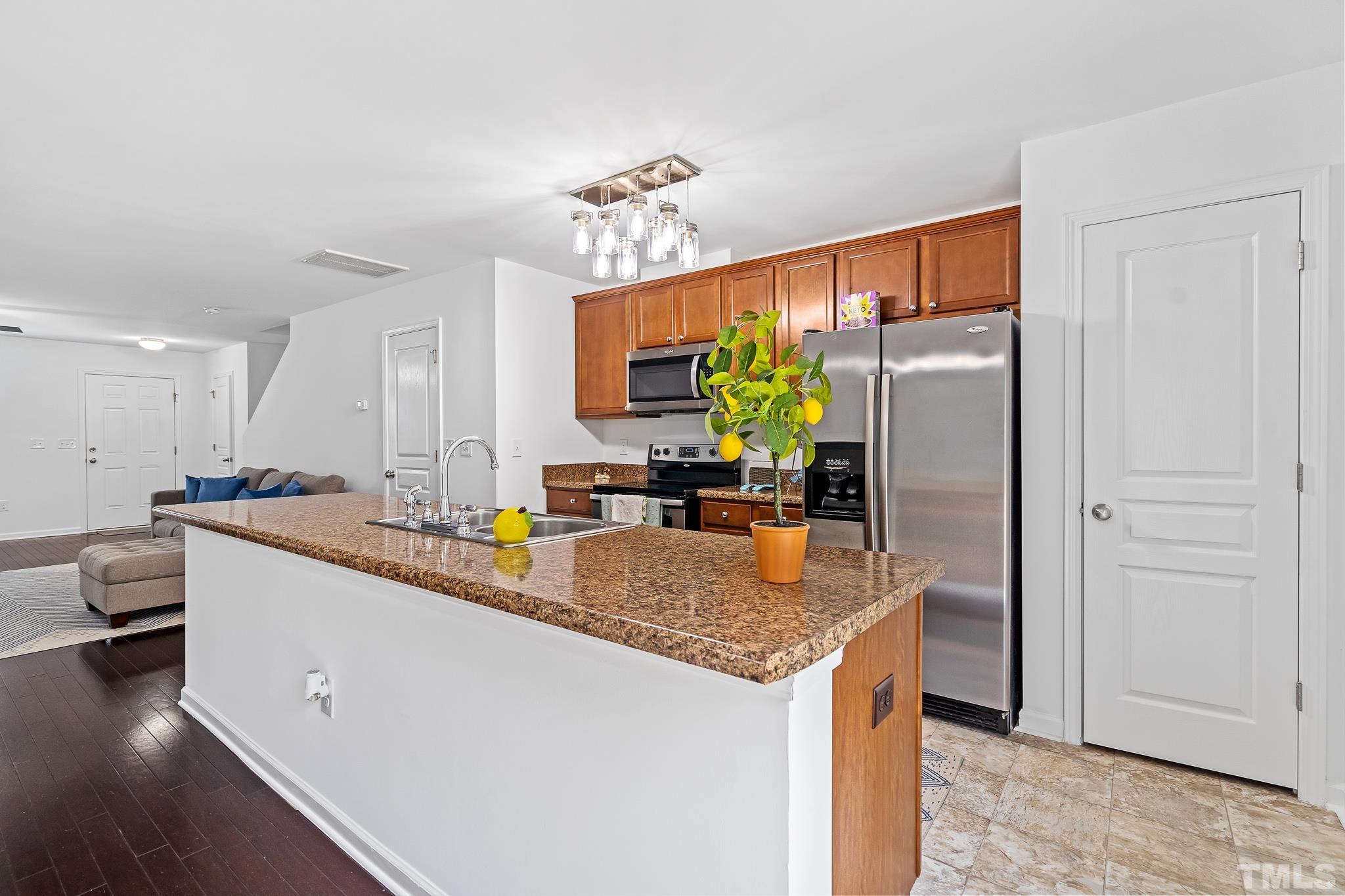 2931 Berkeley Springs Place Raleigh, NC 27616 - Photo 15 of 32 a kitchen with stainless steel appliances granite countertop a sink stove and refrigerator