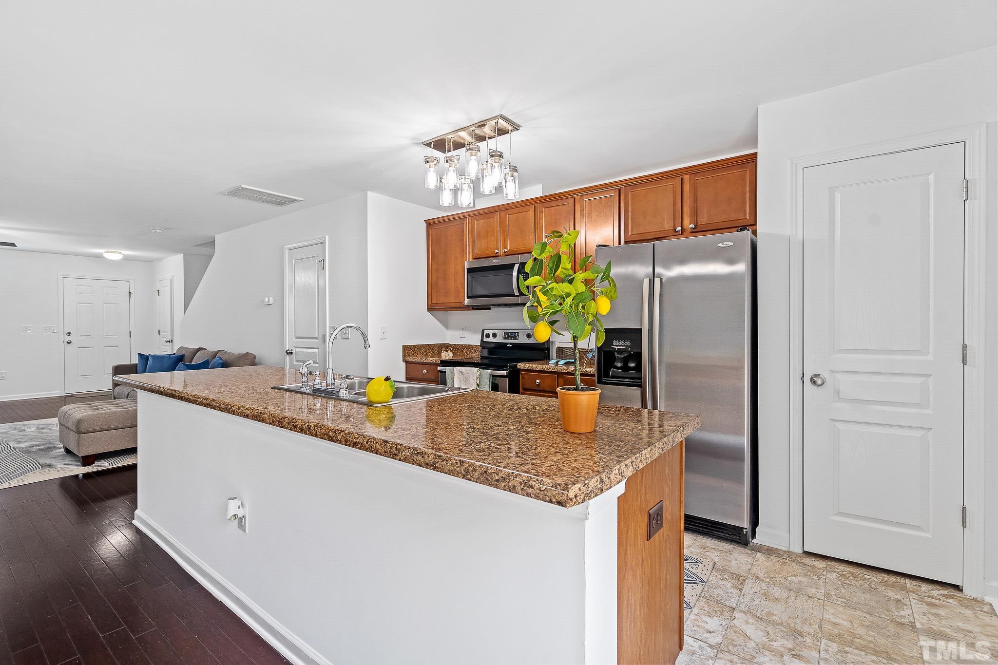 2931 Berkeley Springs Place Raleigh, NC 27616 - Photo 16 of 32 a kitchen with stainless steel appliances granite countertop a sink stove and refrigerator