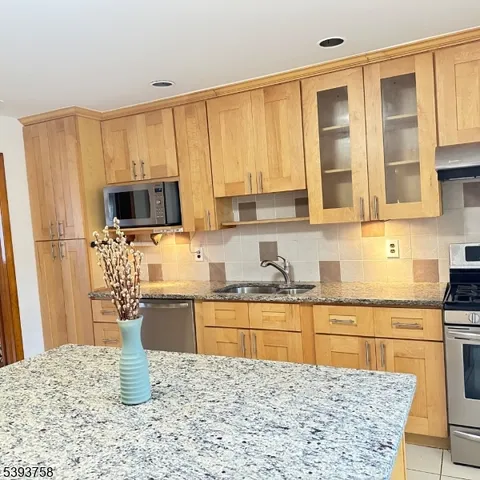 a kitchen with stainless steel appliances granite countertop a stove a sink and a microwave