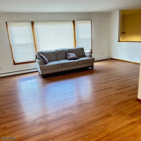 a living room with wooden floor and a window