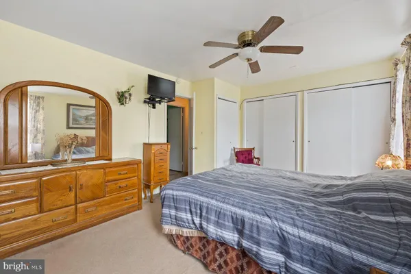 a bedroom with a bed a chair and potted plant