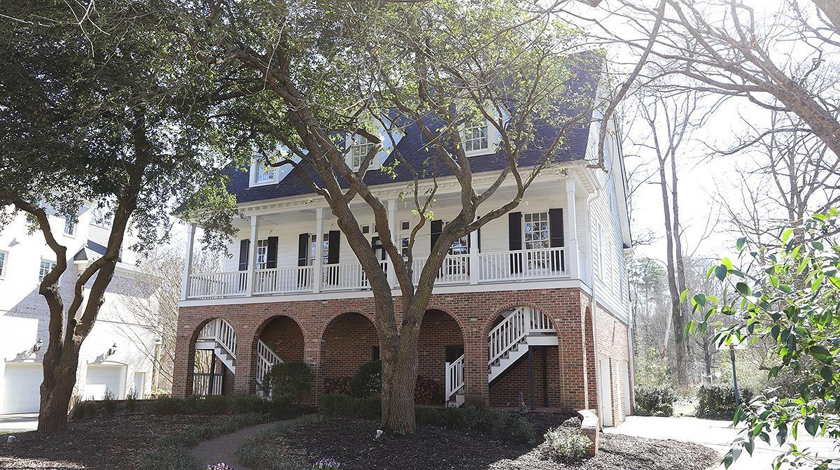 a view of a white house with a large tree