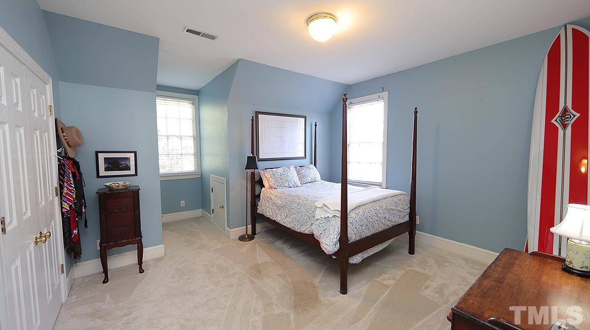 321 Marlowe Road Raleigh, NC 27609 - Photo 17 of 21 a bedroom with a bed and a flat tv screen on dresser