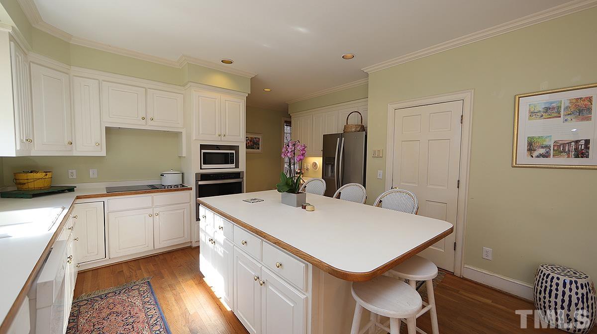 321 Marlowe Road Raleigh, NC 27609 - Photo 9 of 21 a kitchen with a sink a stove a refrigerator and white cabinets