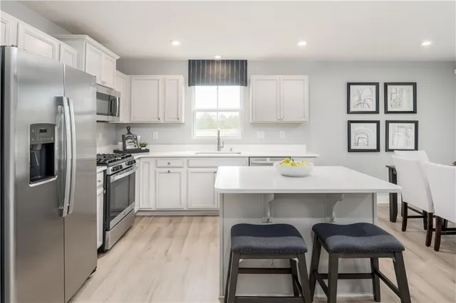a kitchen with a sink chairs and refrigerator
