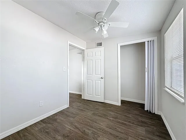 a view of an empty room with wooden floor