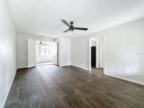 a view of a livingroom with wooden floor and a ceiling fan