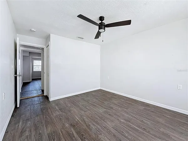 a view of a room with wooden floor and a ceiling fan