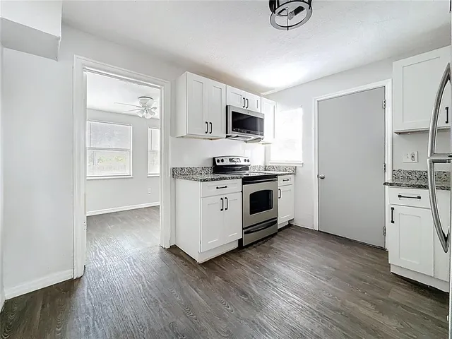 a kitchen with stainless steel appliances a white stove top oven and a refrigerator