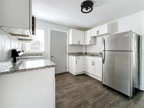 a kitchen with a refrigerator sink and cabinets