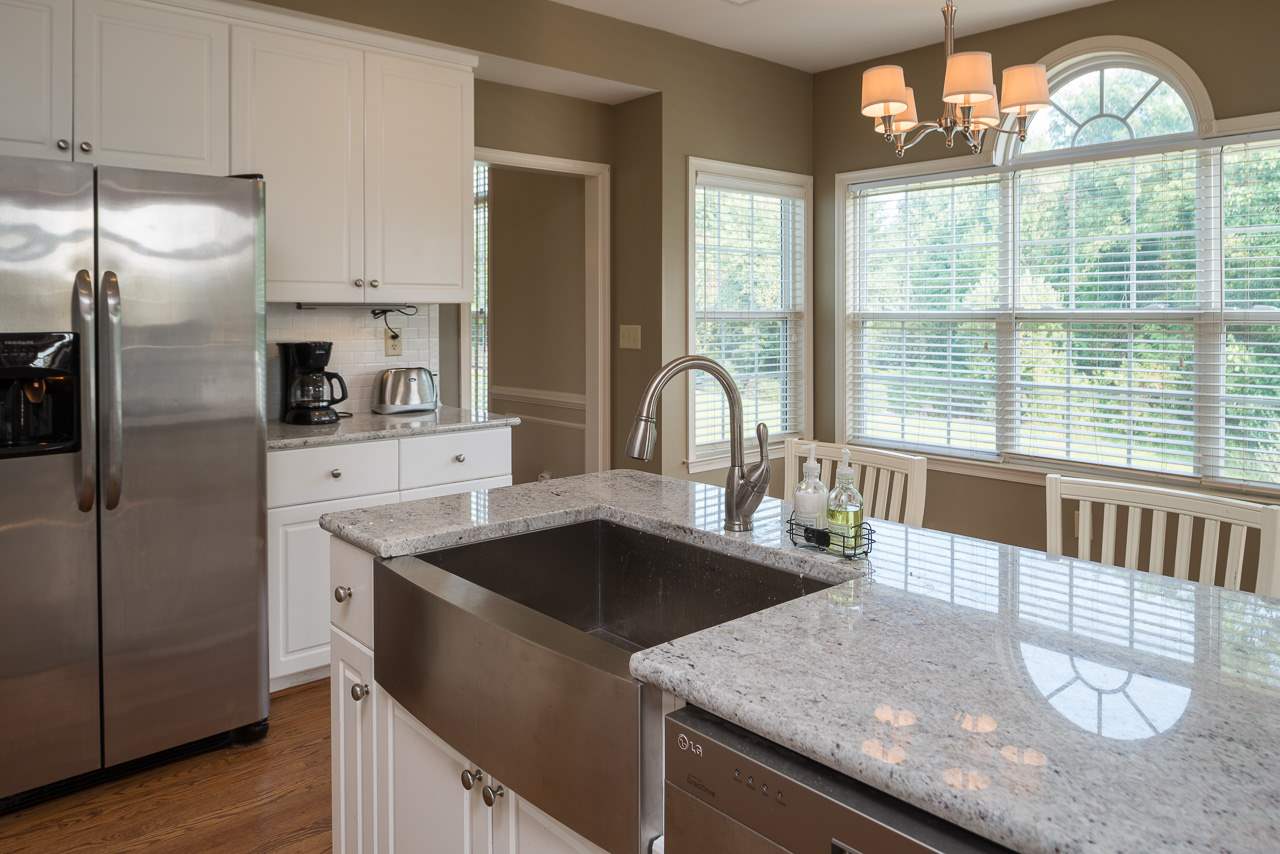 5383 Windy Ridge Road Charlottesville, VA 22903 - Photo 6 of 19 a kitchen with stainless steel appliances granite countertop a sink a refrigerator and a stove with wooden floor