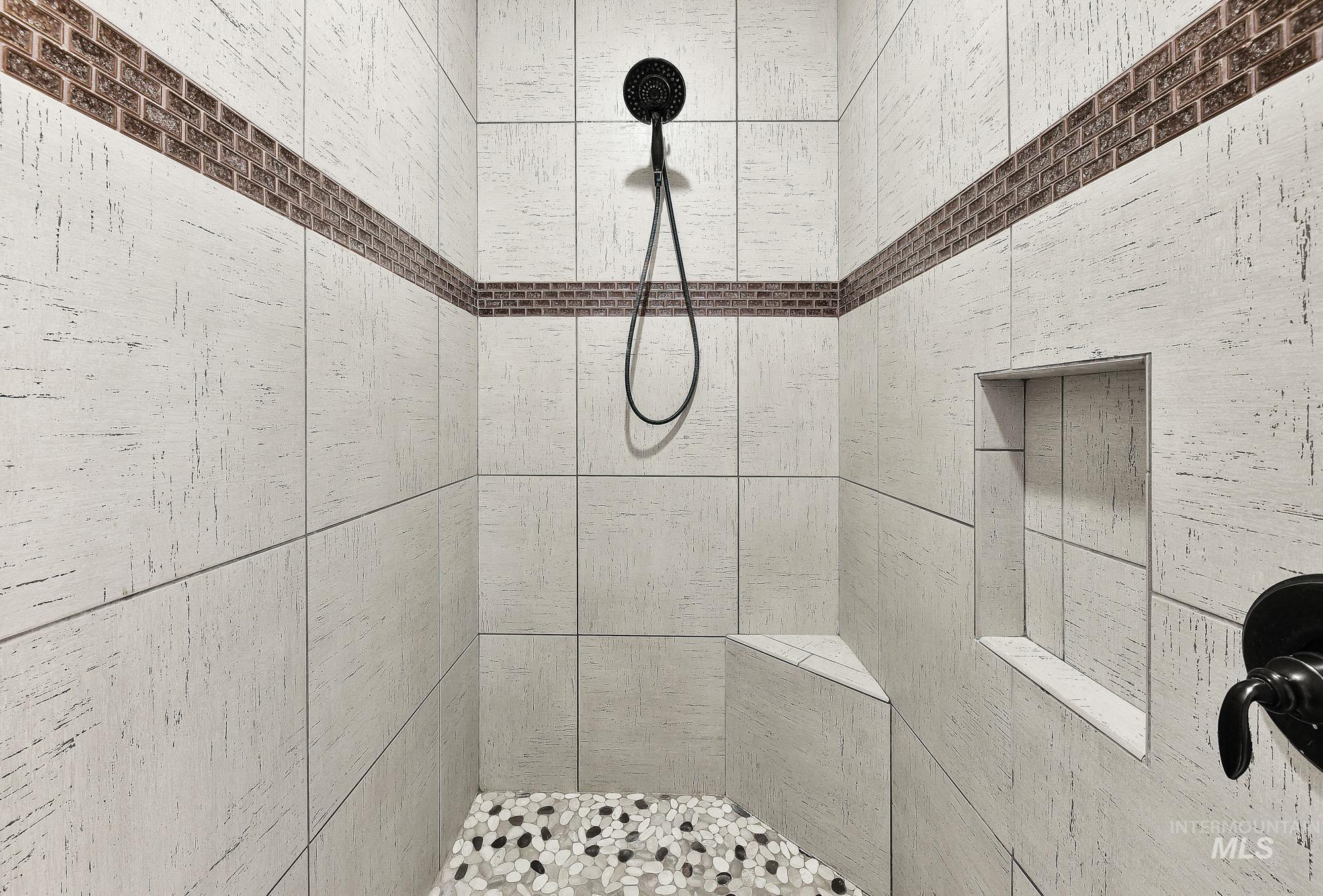 220 South Wildgrass Way Star, ID 83669 - Photo 21 of 50 Walk-in shower with gray subway tile surround and pebble flooring
