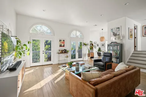 a living room with furniture fireplace and a large window