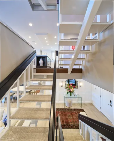 a kitchen with stainless steel appliances granite countertop a stove top oven a sink a dining table and chairs with wooden floor