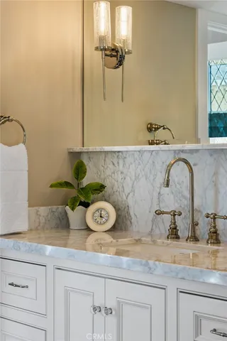 a bathroom with a granite countertop sink a mirror and shower