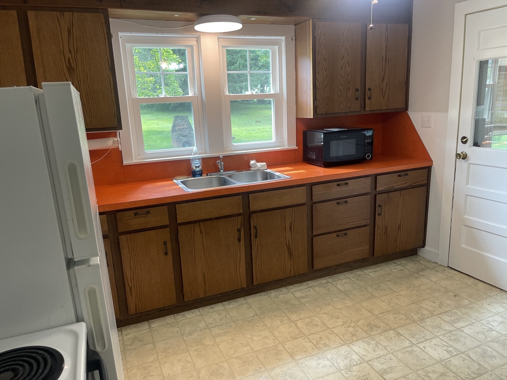 30 Wilbraham Road Monson, MA 01057 - Photo 10 of 11 a kitchen with stainless steel appliances granite countertop a sink a refrigerator a stove a washer and dryer