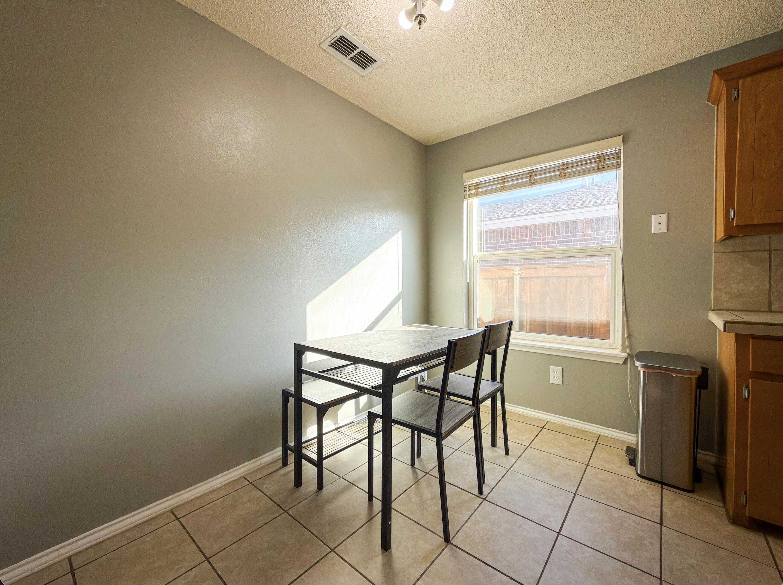 6123 39th Street Lubbock, TX 79407 - Photo 5 of 13 a dining room with furniture and a window
