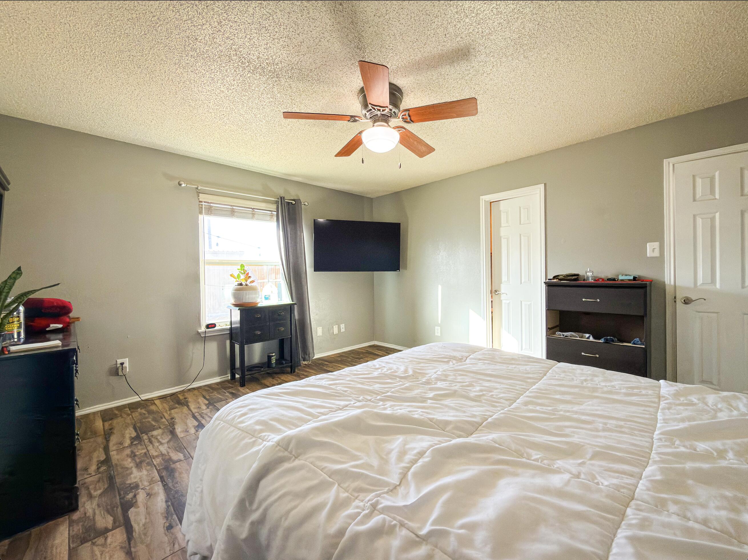 6123 39th Street Lubbock, TX 79407 - Photo 7 of 13 a bedroom with a bed and a chandelier