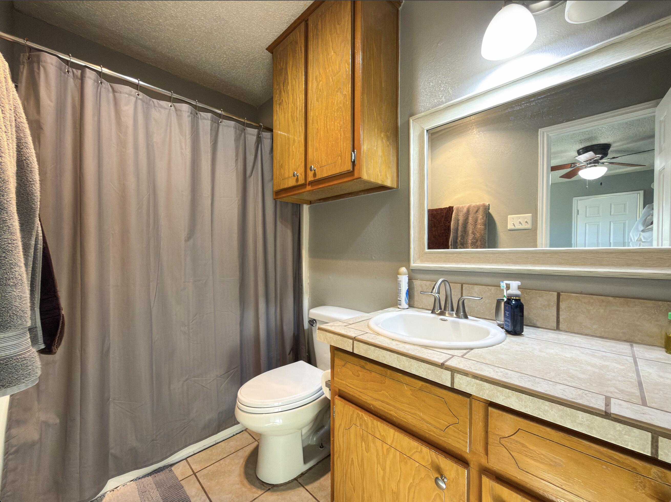 6123 39th Street Lubbock, TX 79407 - Photo 8 of 13 a bathroom with a granite countertop sink and a mirror