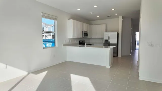 a kitchen with kitchen island sink stove and refrigerator