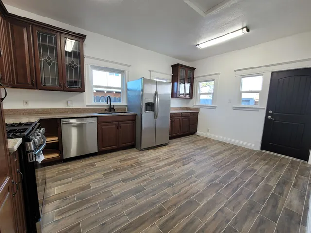 a kitchen with stainless steel appliances granite countertop a refrigerator and a stove