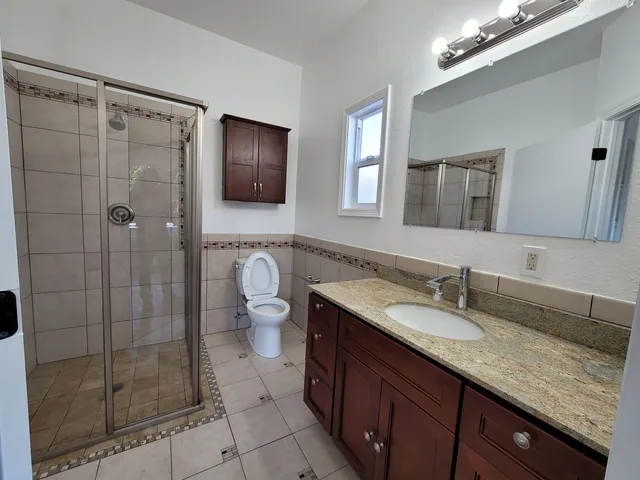 a spacious bathroom with a granite countertop sink mirror and shower
