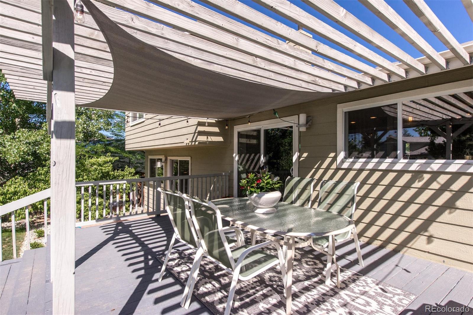 100 Prairie Ridge Road Highlands Ranch, CO 80126 - Photo 31 of 34 a view of a patio with table and chairs with wooden floor and fence