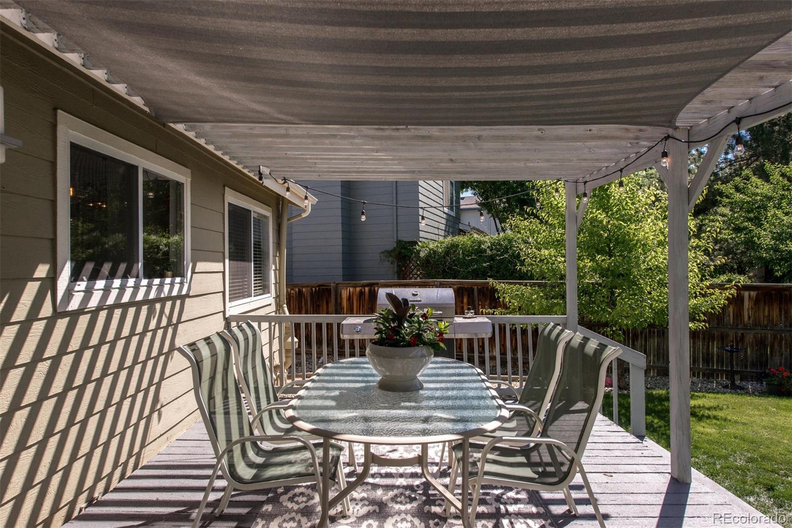 100 Prairie Ridge Road Highlands Ranch, CO 80126 - Photo 32 of 34 a view of a patio with table and chairs potted plants with floor to ceiling window