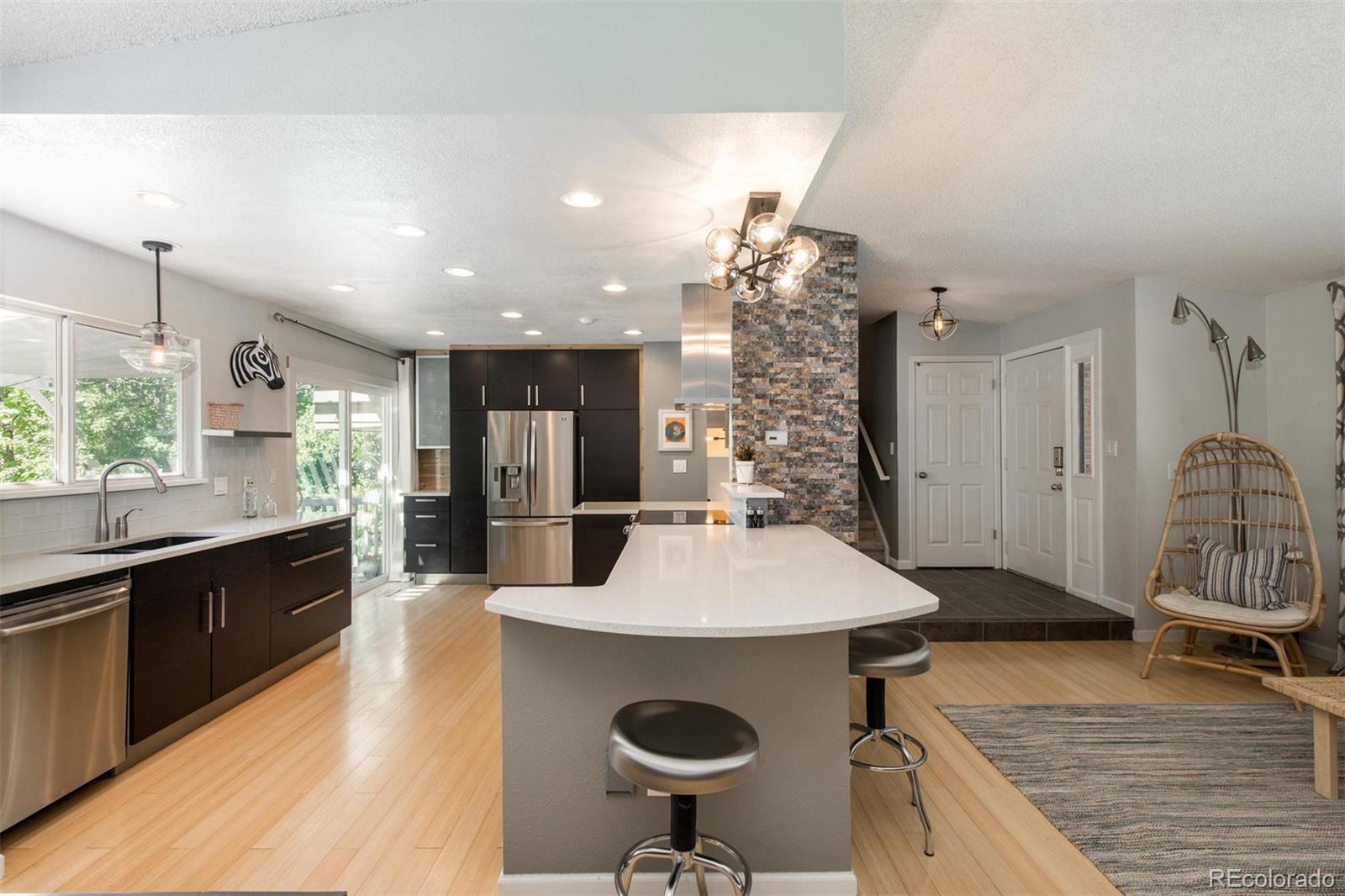 100 Prairie Ridge Road Highlands Ranch, CO 80126 - Photo 4 of 34 a kitchen with a sink a stove and chairs