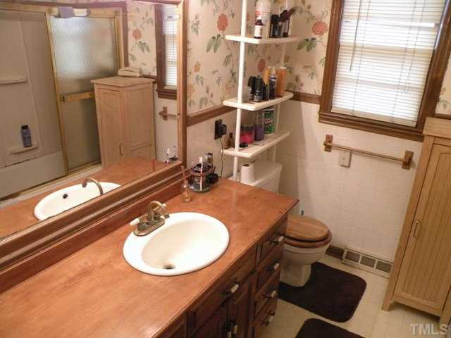 1205 Legend Road Raleigh, NC 27603 - Photo 8 of 11 a bathroom with a sink mirror vanity and toilet