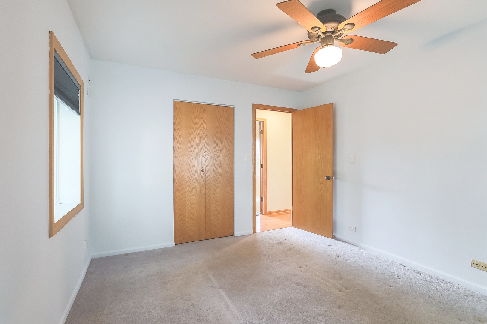 353 Raupp Boulevard Buffalo Grove, IL 60089 - Photo 15 of 28 a view of a bedroom with a ceiling fan and a window