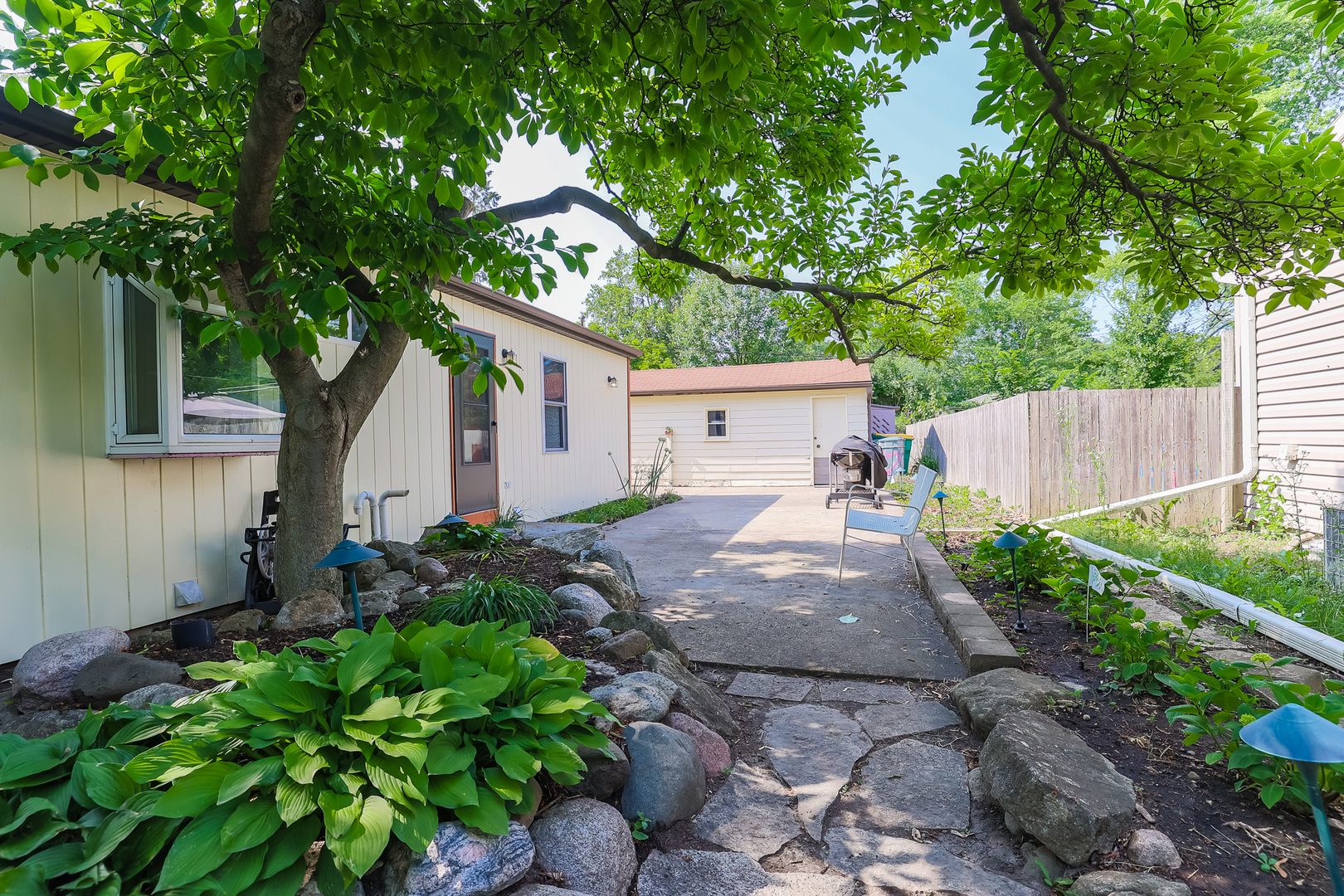 353 Raupp Boulevard Buffalo Grove, IL 60089 - Photo 28 of 28 a backyard of a house with plants and large tree