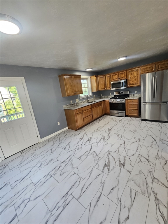 40 Merrick Street, Unit A Worcester, MA 01609 - Photo 30 of 32 a kitchen with stainless steel appliances a stove a refrigerator and a sink