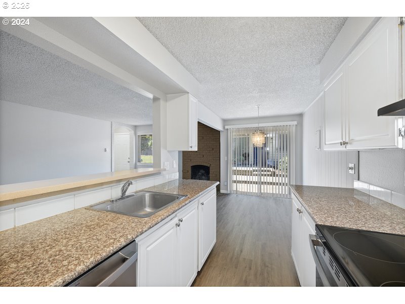 2921 Northeast Rene Avenue, Unit 15B Gresham, OR 97030 - Photo 2 of 22 a kitchen with granite countertop a sink and a stove with wooden floor
