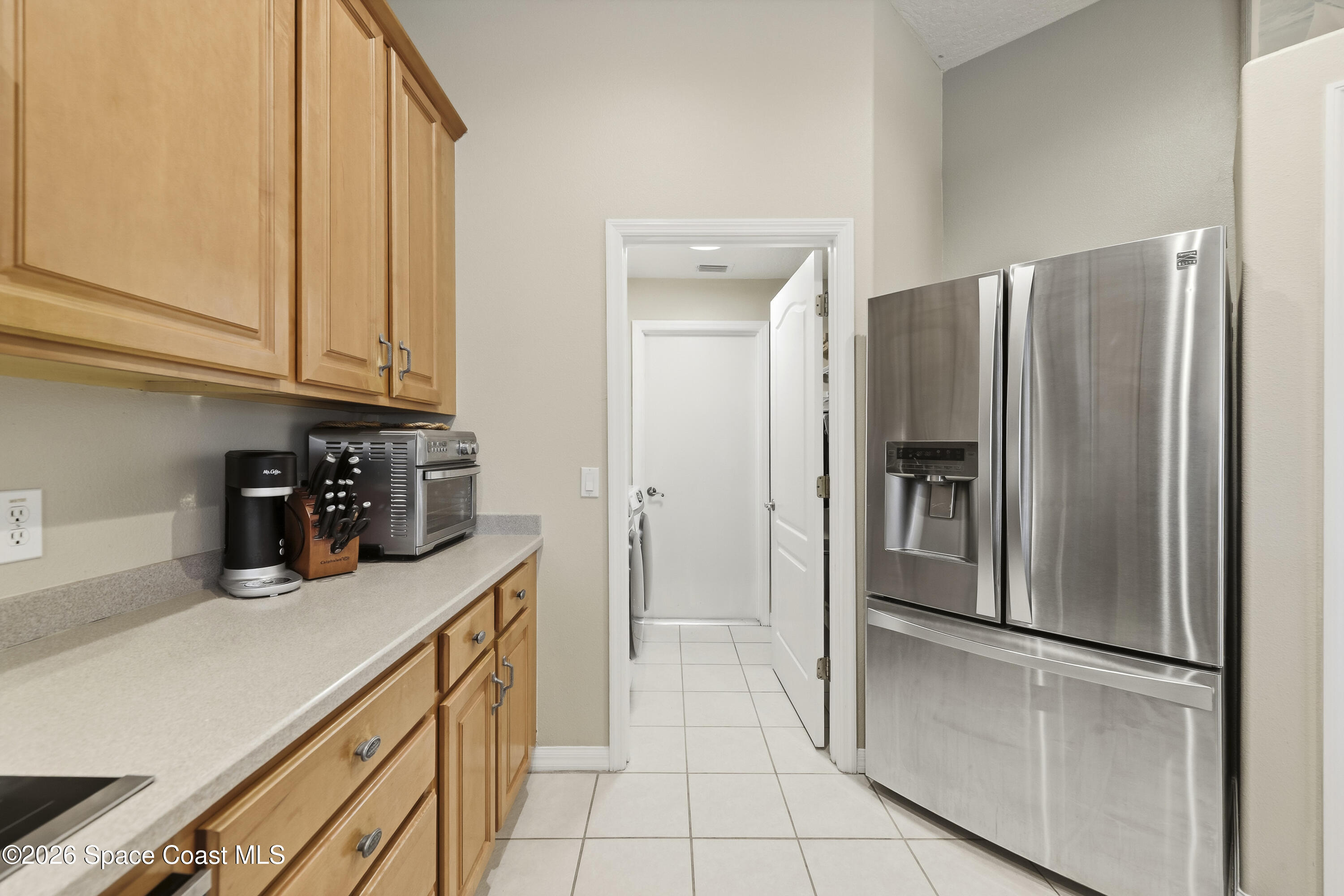 1643 Long Pine Road Melbourne, FL 32940 - Photo 21 of 63 a kitchen with a refrigerator and cabinets