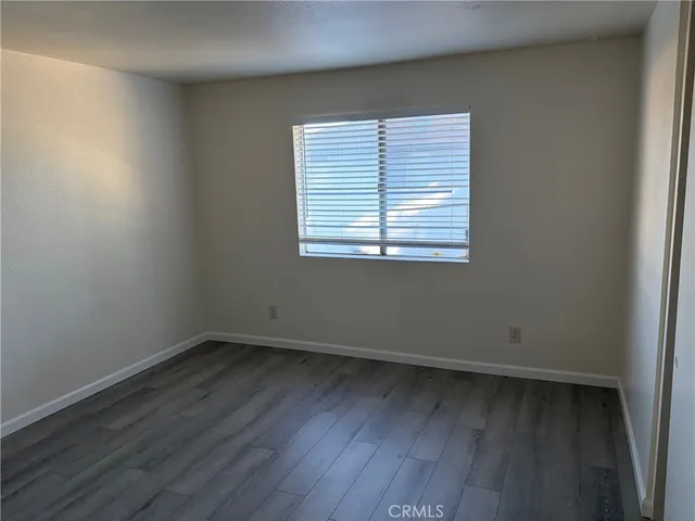 an empty room with wooden floor and a window