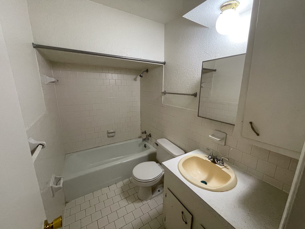 704 Cline Street Huntsville, TX 77340 - Photo 12 of 21 a bathroom with a granite countertop sink toilet and a mirror