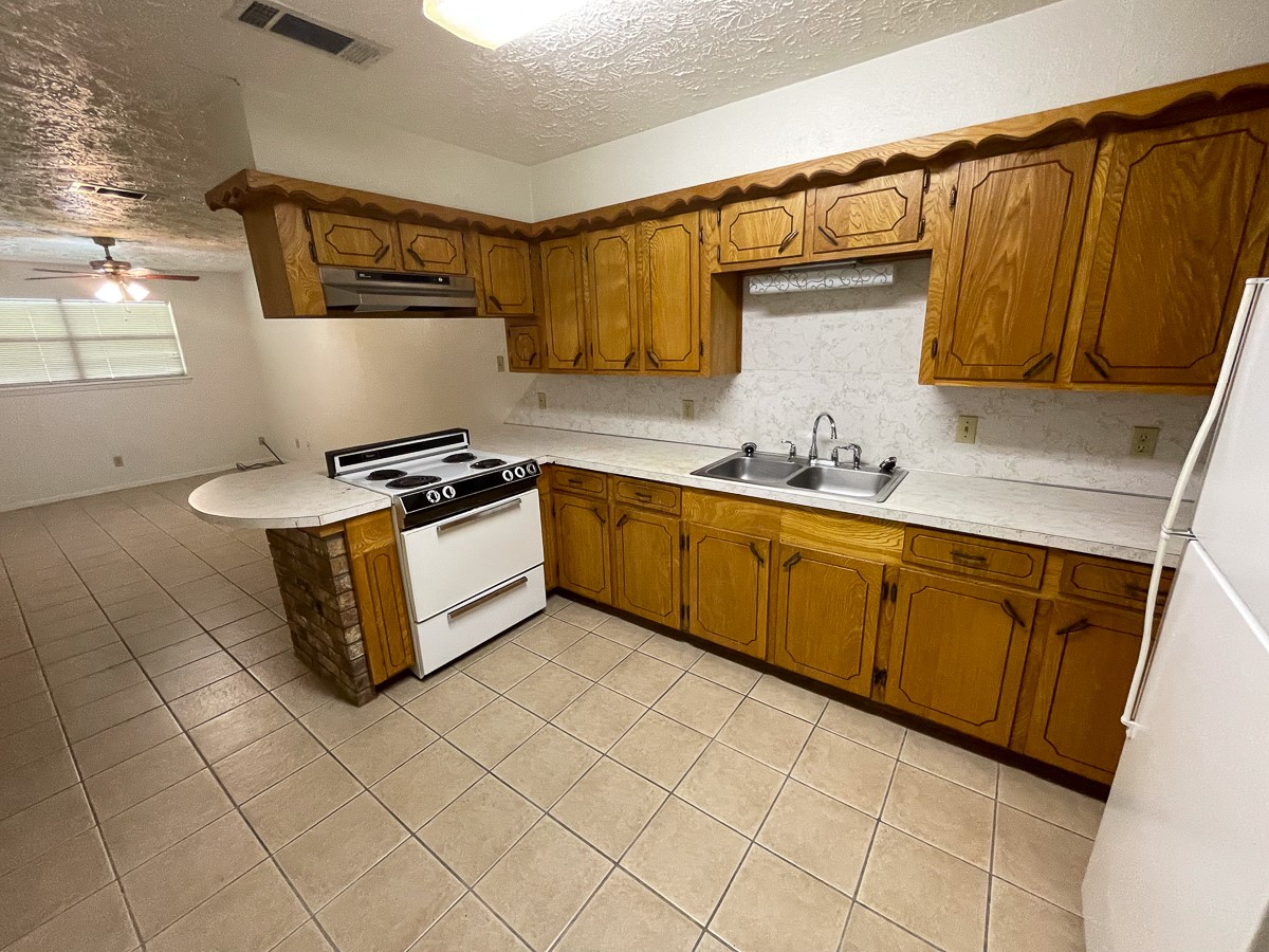 704 Cline Street Huntsville, TX 77340 - Photo 13 of 21 a kitchen with stainless steel appliances a sink dishwasher stove refrigerator and cabinets