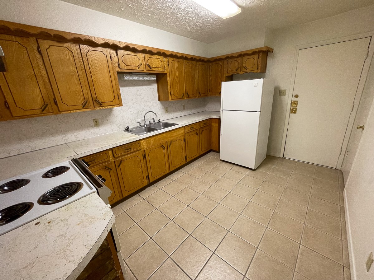 704 Cline Street Huntsville, TX 77340 - Photo 14 of 21 a kitchen with a refrigerator and a sink