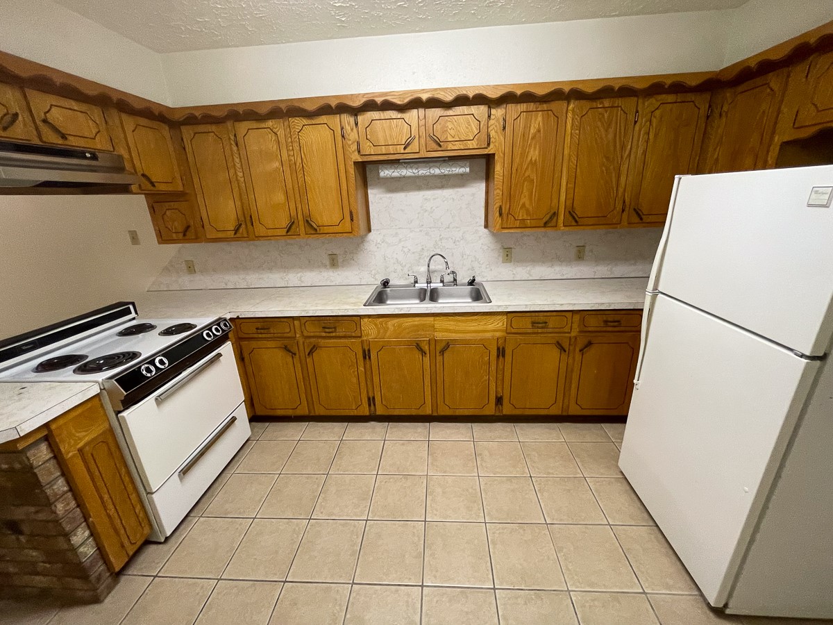 704 Cline Street Huntsville, TX 77340 - Photo 15 of 21 a kitchen with a refrigerator sink and cabinets
