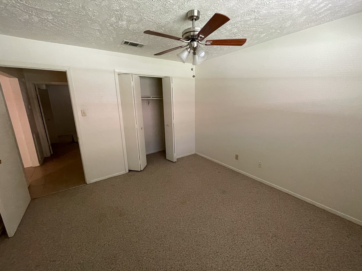 704 Cline Street Huntsville, TX 77340 - Photo 9 of 21 an empty room with a ceiling fan and a window