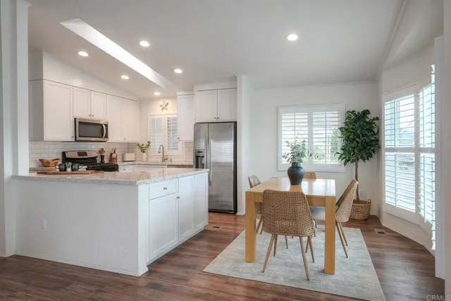 a kitchen with sink a refrigerator and chairs