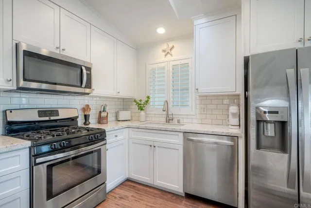 a kitchen with cabinets stainless steel appliances and a counter space