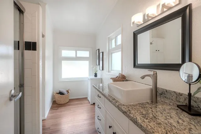 a spacious bathroom with a granite countertop sink and a mirror