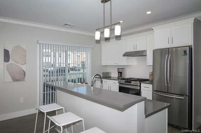 a kitchen with kitchen island a large counter top space appliances and cabinets